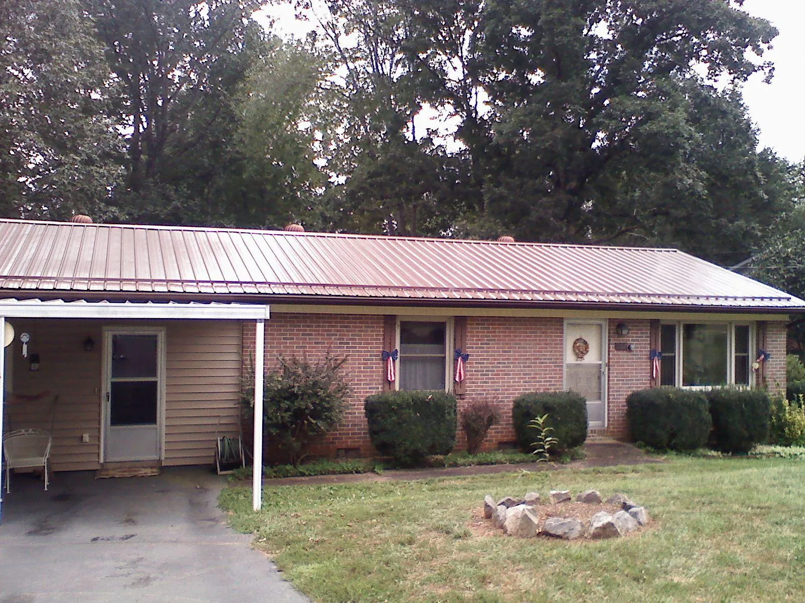 Bronze metal roof and carport on a brick ranch home — Roof Repair work by our crew in Rutland